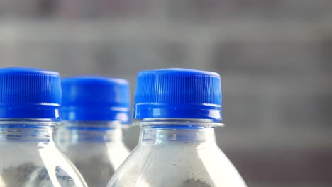 close up of a row of water bottles with blue caps