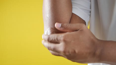 man applying lotion to elbow