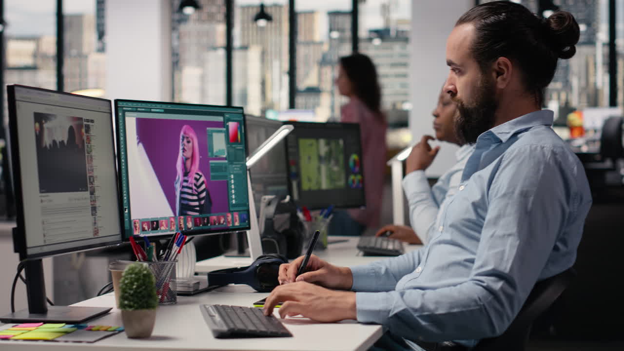 Male specialist editing photography on computer with retouching software tools