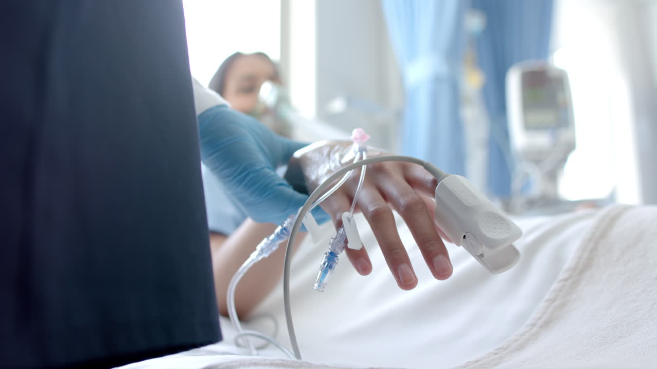 남성 의사가 두 인종의 여성 환자의 손가락에 산소 측정기를 붙여 침대에 누워있는 모습, 복사 공간, 느린 동작