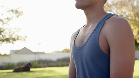 Focused-biracial-man-practicing-yoga-meditation-in-sunny-garden,-slow-motion