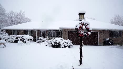 Cozy-suburban-house-covered-in-snow-and-heavily-decorated-for-Christmas-with-Lights,-wreaths,-and-fake-deer