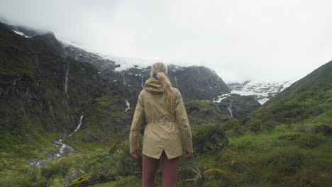 adventure hiker soaking in stunning view of rob roy glacier valley, new zealand