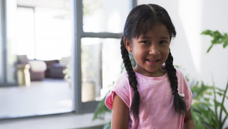 Biracial-girl-with-a-bright-smile,-wearing-a-pink-top,-with-copy-space