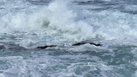 Olas-Del-Océano-Rompiendo-Y-Rociando-Juntas-Durante-La-Marea-Real-Sobre-El-Océano-Azul-Y-El-Cielo-Azul