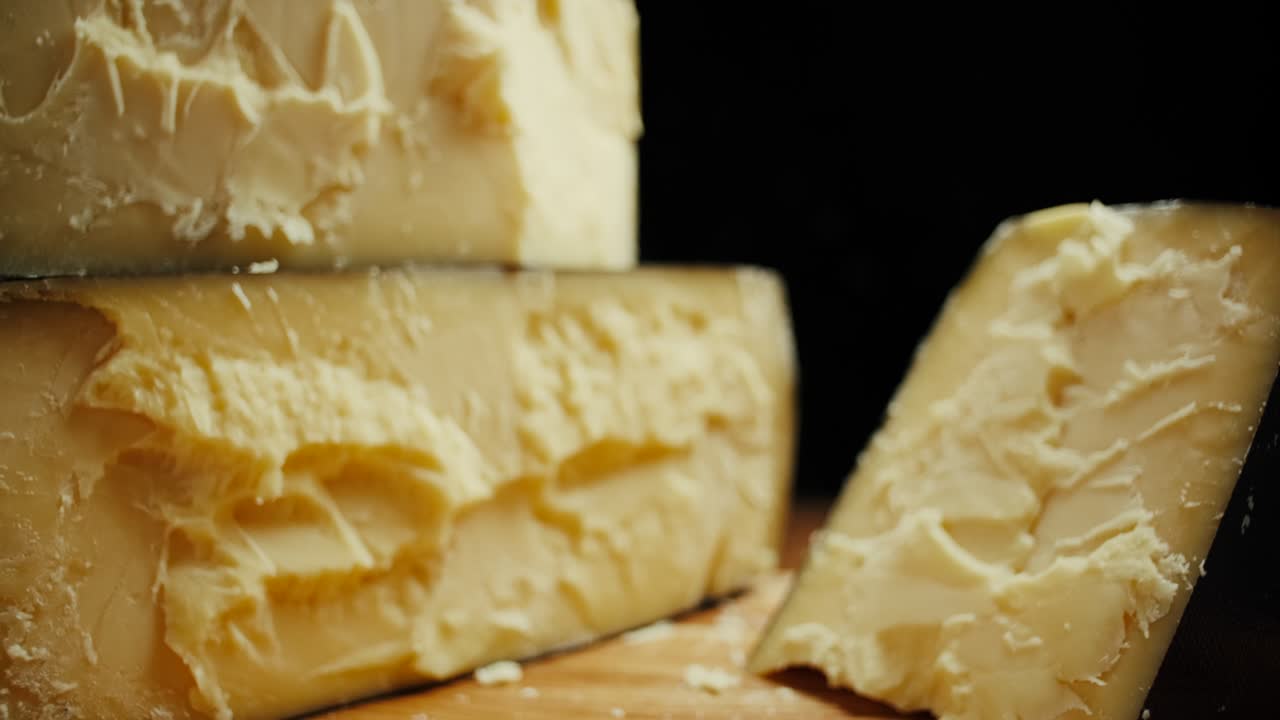 queso de cabeza dura media parmesano en tablero de madera. disparo de dolly-out