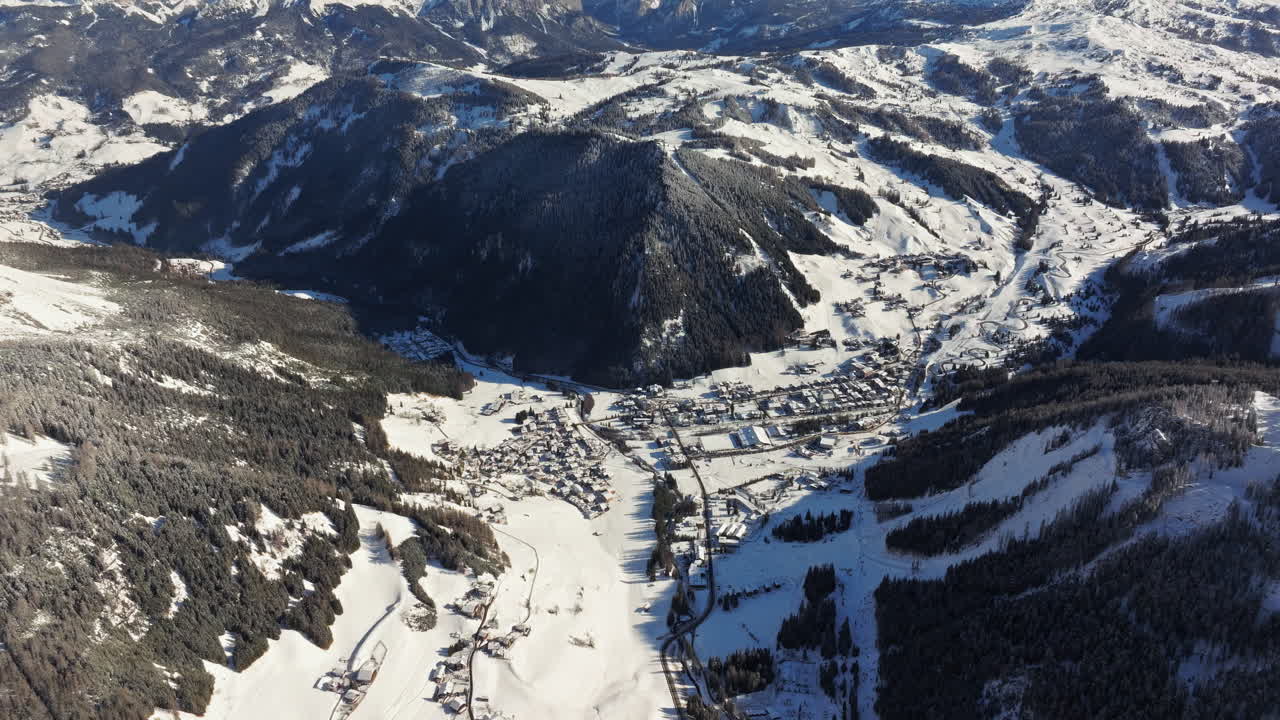 Aerial drone view of the Colfosco mountain village covered in snow, in South Tyrol, Dolomites, Northern Italy