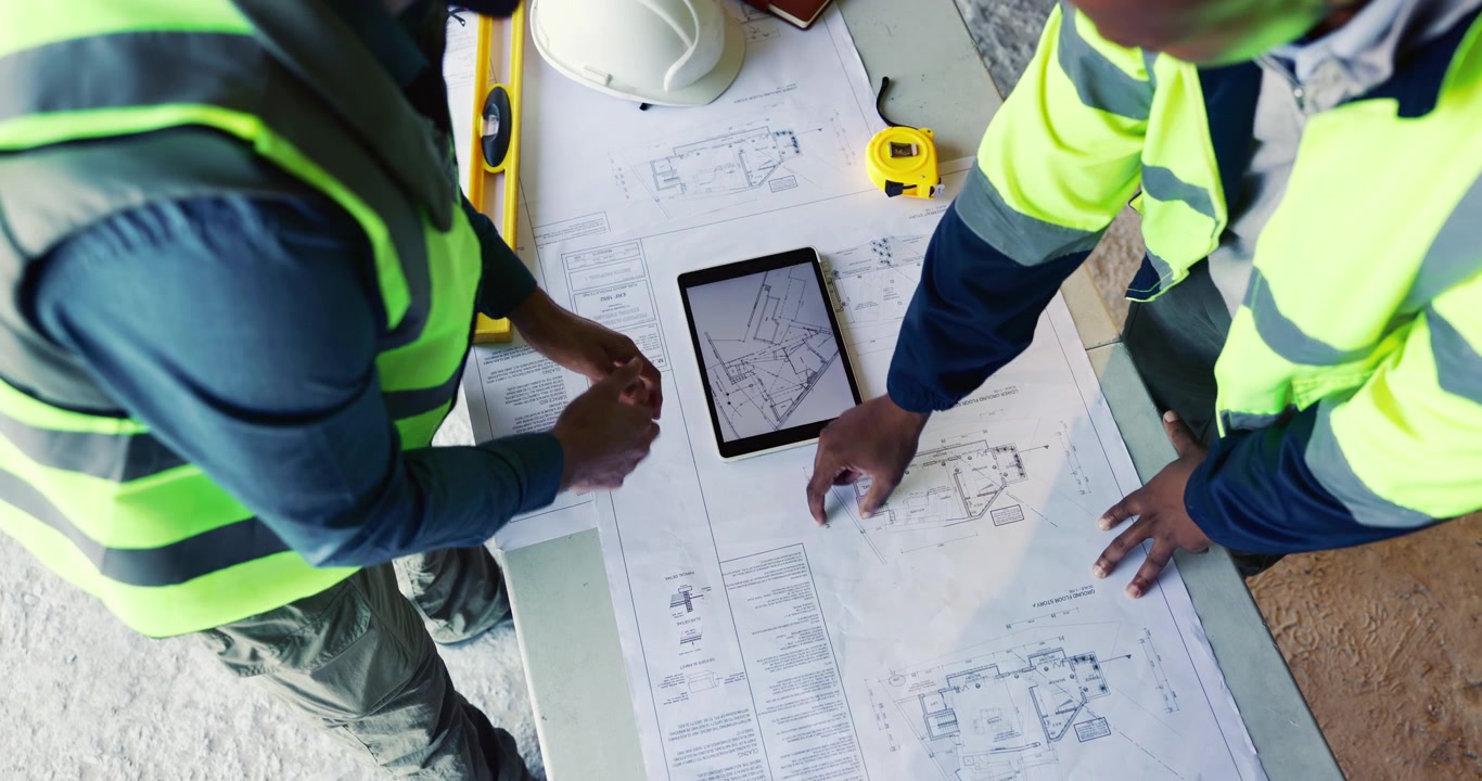 Architects Reviewing Construction Blueprints on Tablet at Building Site