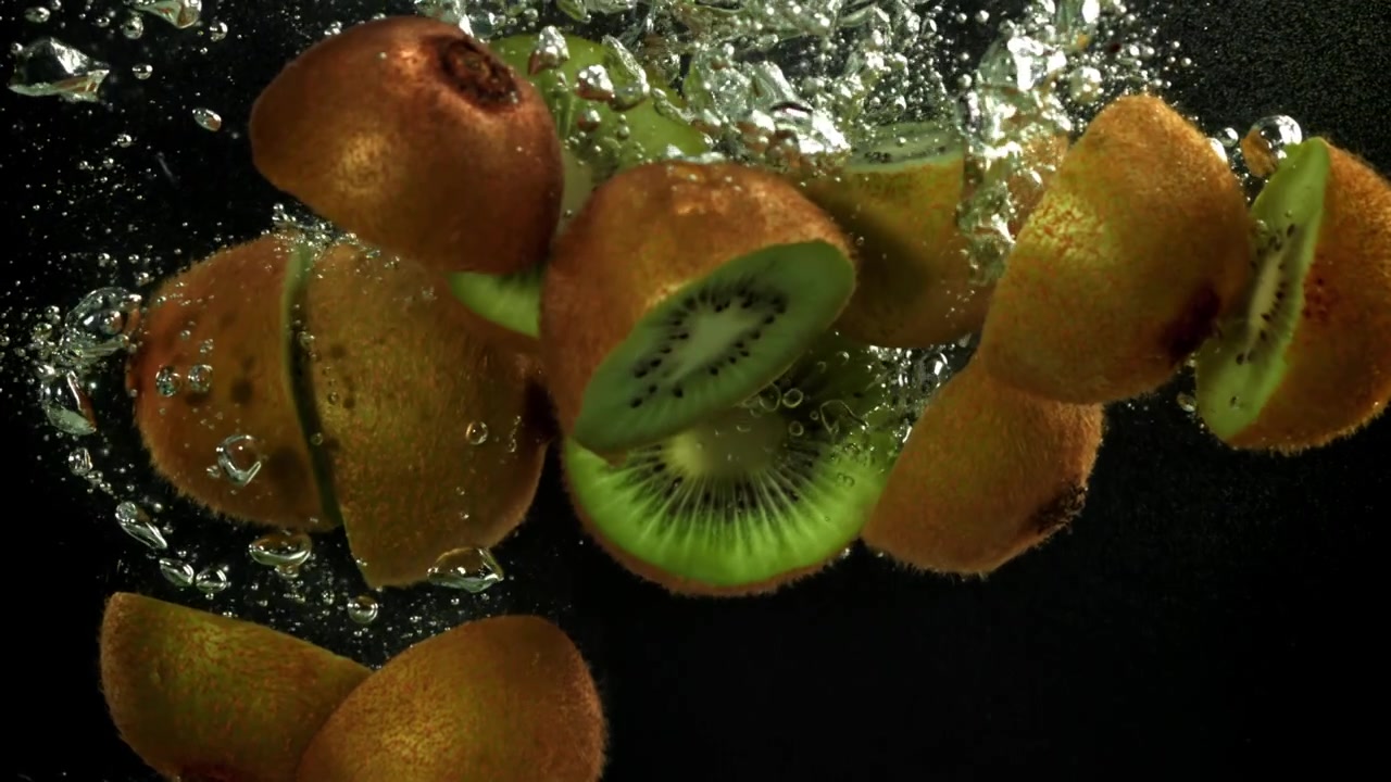 Fresh Kiwi Fruit Halves Falling into Water with Bubbles