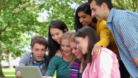 estudiantes mirando la computadora portátil juntos y riendo