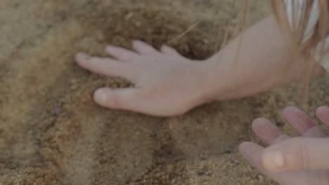 woman hand enjoying playing with sand