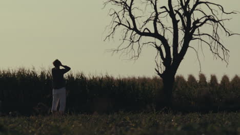 contemplative figure in rural landscape at sunset
