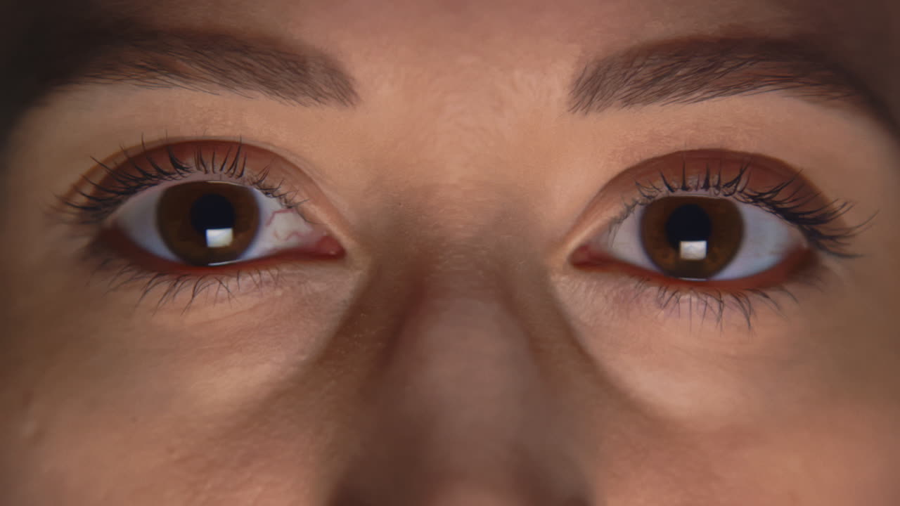 백인 여성이 눈을 뜨고  ⁇ 박이고 있습니다.