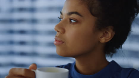 african-american-businesswoman-holding-cup-of-coffee.-Female-worker-biting-lips