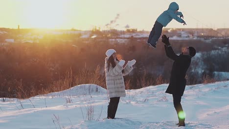 Aufregende-Familie-Entspannt-Sich-Auf-Verschneitem-Rasen-Bei-Sonnenuntergang-In-Zeitlupe