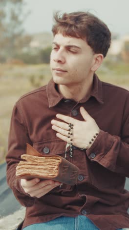 happy and joyful man praying in the nature with the bible book