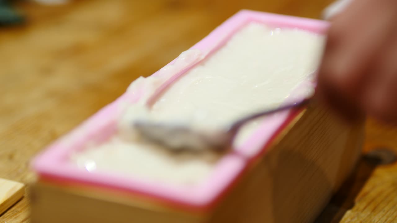Smoothing off new batch of homemade bar soap in mold