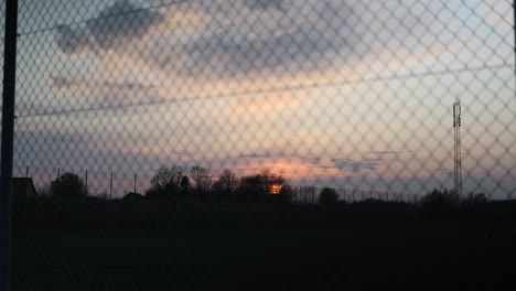 sunset seen through wire fence