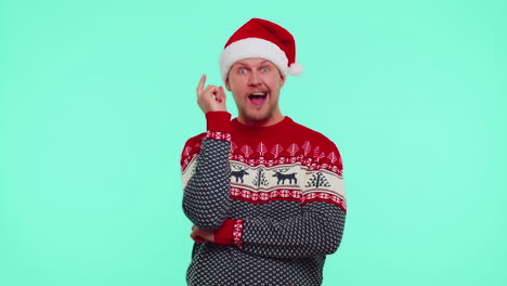 Excited-man-in-red-Christmas-sweater-make-gesture-raises-finger-came-up-with-creative-plan-good-idea