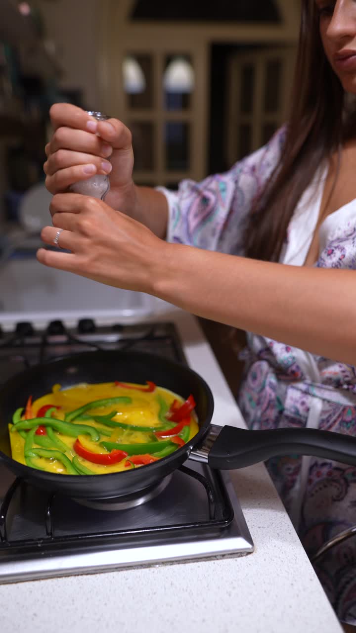 mujer cocinando huevos con pimientos