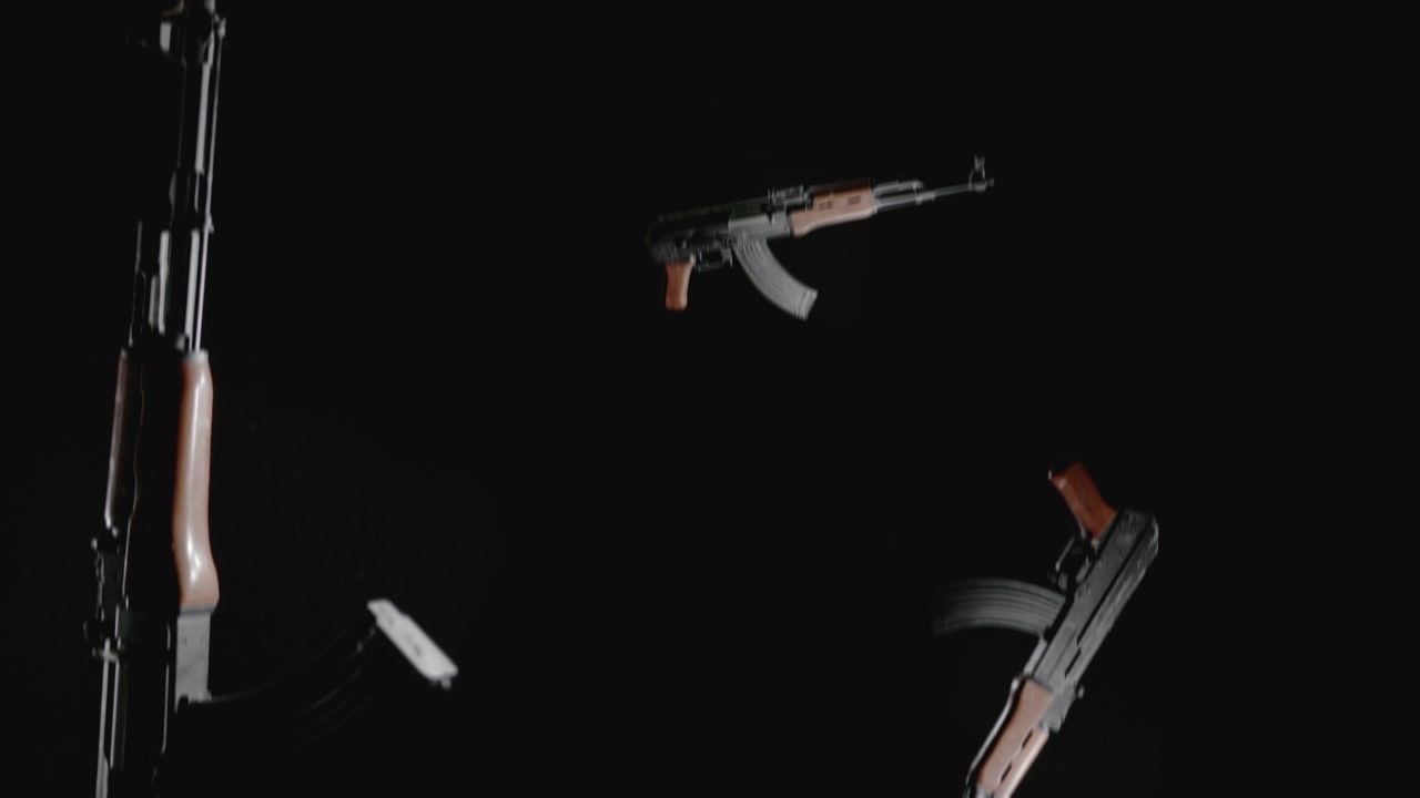 Machineguns on the dark background are falling in slowmotion