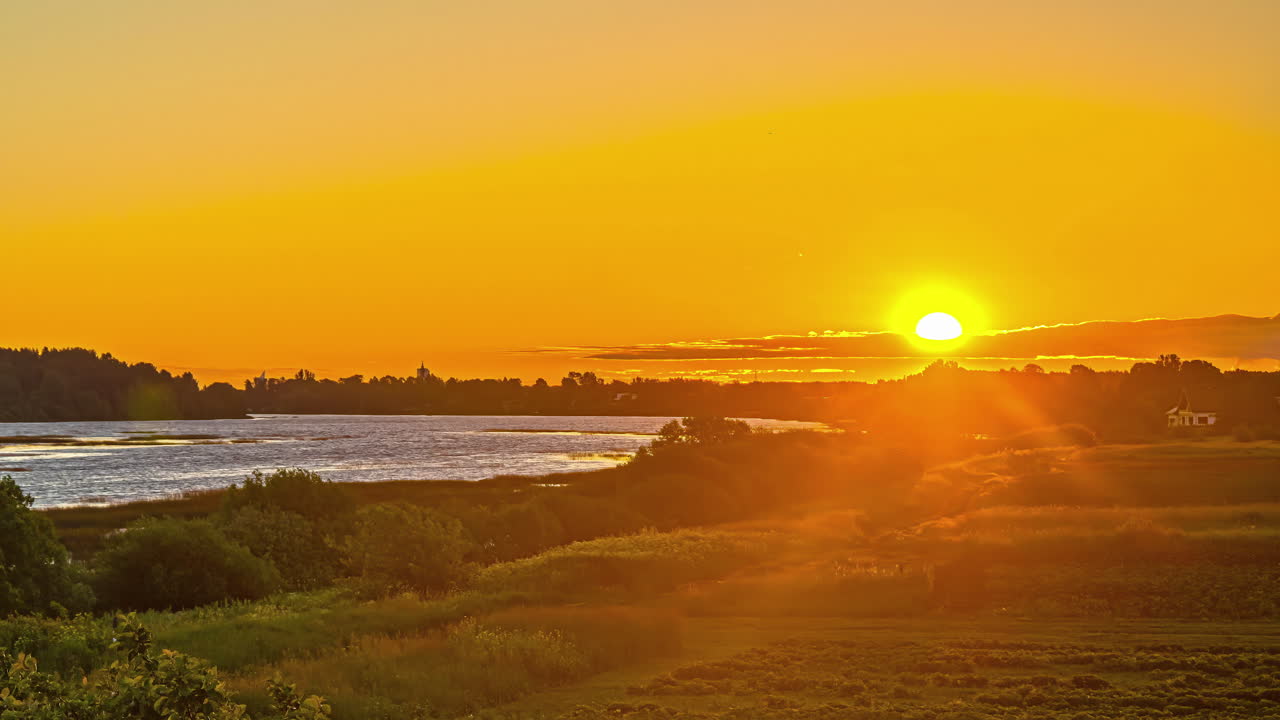 timelapse estático do nascer do sol laranja por natureza verde e água costeira