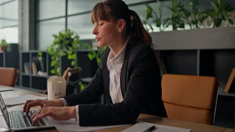 woman relaxing at her work desk, having lunch