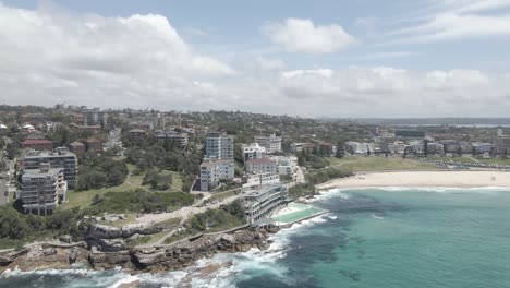 Nubes-En-El-Cielo-Azul-Sobre-La-Playa-De-Bondi,-Hoteles-Y-Piscina-De-Icebergs-De-Bondi-En-Verano