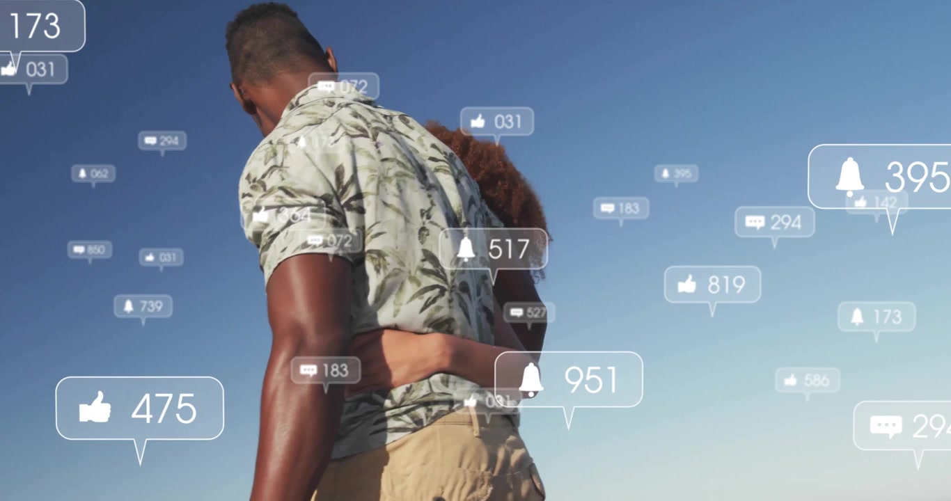 Couple walking along beach starting floating social media icons signaling online interest