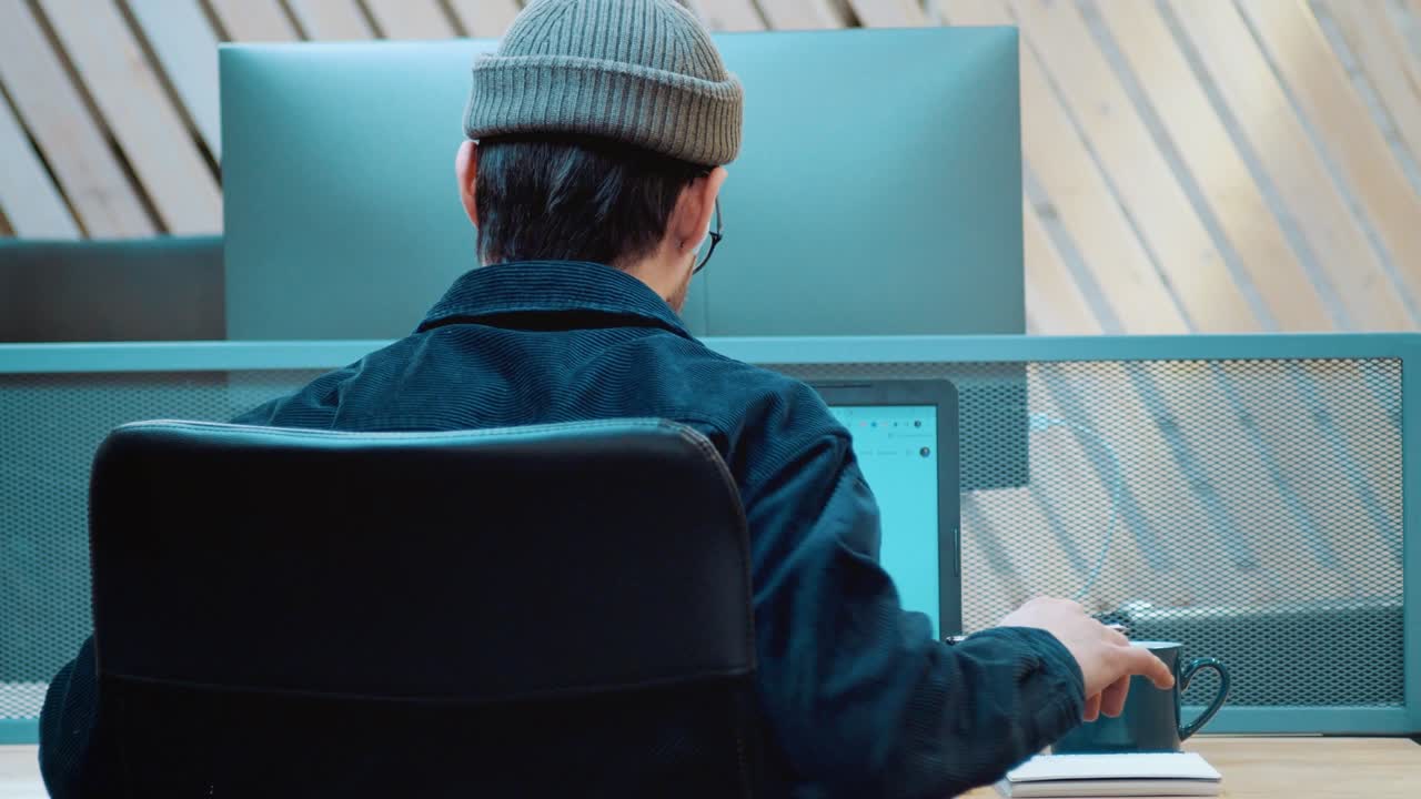 젊은 학생이 과제를 수행합니다. 당신의 등은 열심히 일해서 아니다. 그의 손으로 움직입니다.