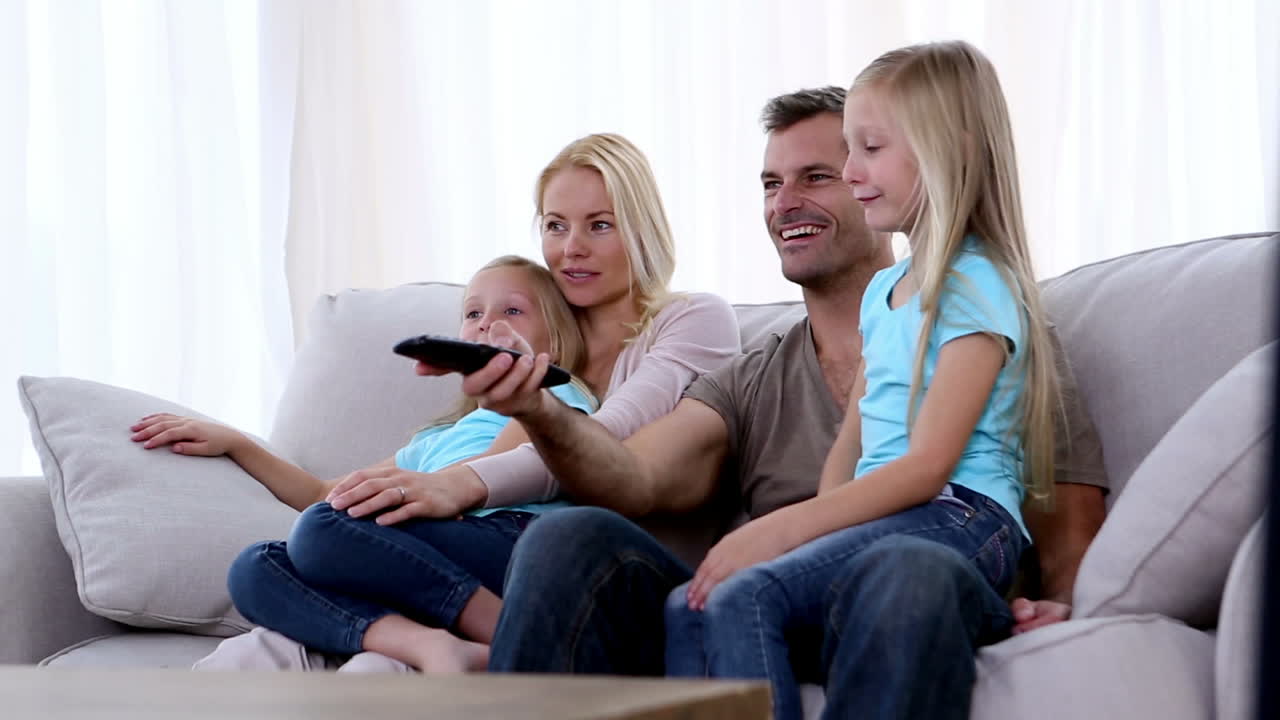 Familie ser fjernsyn i sofaen