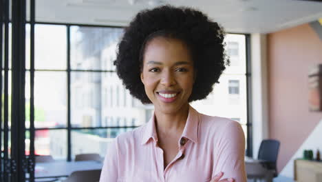 Portrait-Of-Smiling-Businesswoman-Standing-In-Empty-Office