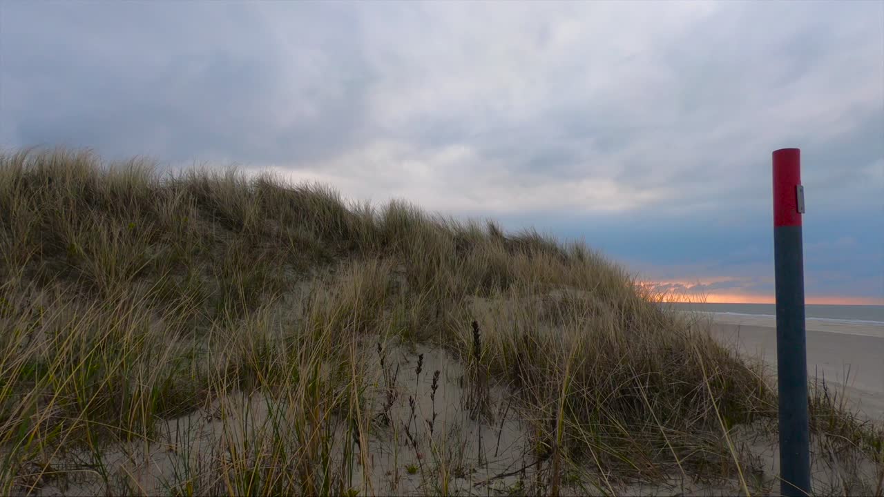 Giornata ventosa in spiaggia con il tramonto e le onde dell'oceano sullo sfondo