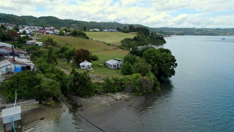 Aerial-Drone-Landscape-Fly-Above-Shore-Houses,-Sea-Coastline-in-Dalcahue-Chilo?