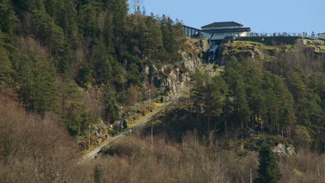looking up to the floibanen funicular railway upper station with blue train carriage going down