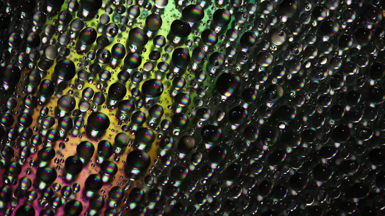 Colorful Water Droplets Reflecting Light on Dark Background