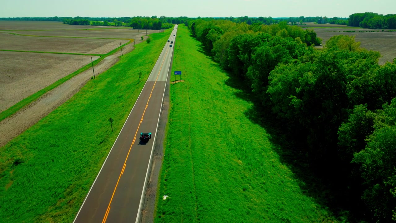 Auto che superano il cartello del confine del Missouri su un'autostrada rurale. Cattura l'affidabilità dei viaggi interstatali e della logistica regionale