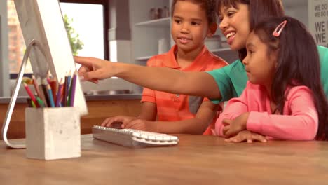 Smiling-Hispanic-mother-on-computer-with-her-children