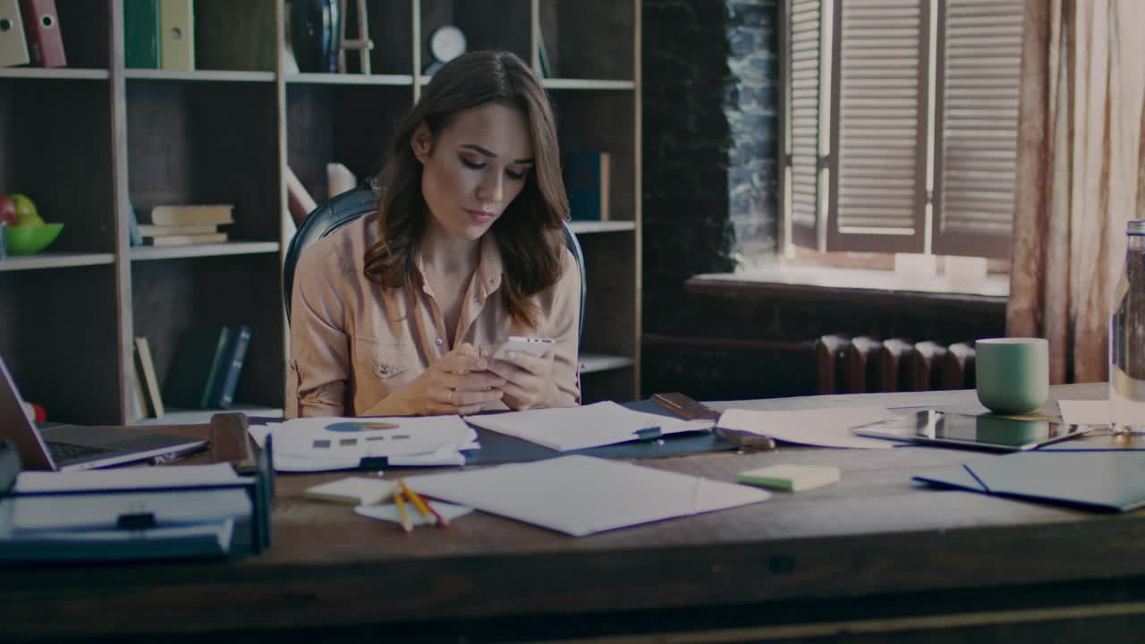 Young businesswoman reading bad news on mobile phone