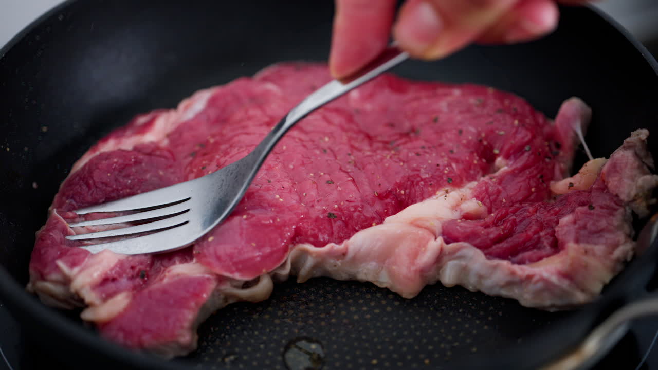 Woman cooking a rump steak on a pan