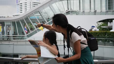 mother and daughter looking a map backpack travel in the city