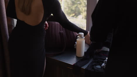 woman packing a travel bag by the window