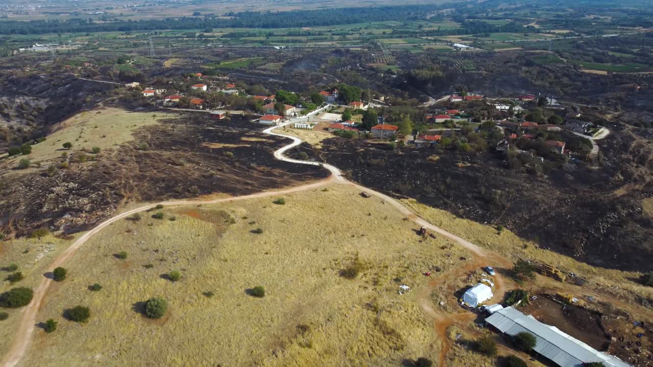 retiro aéreo lento sobre un pueblo rodeado de tierra quemada después de un incendio forestal en el norte de grecia, agosto de 2023
