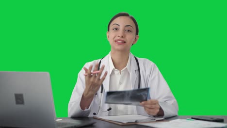 Happy-Indian-female-doctor-explaining-X-ray-report-to-patient-Green-screen