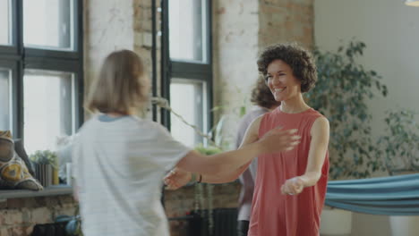 yoga teacher greeting women before practice