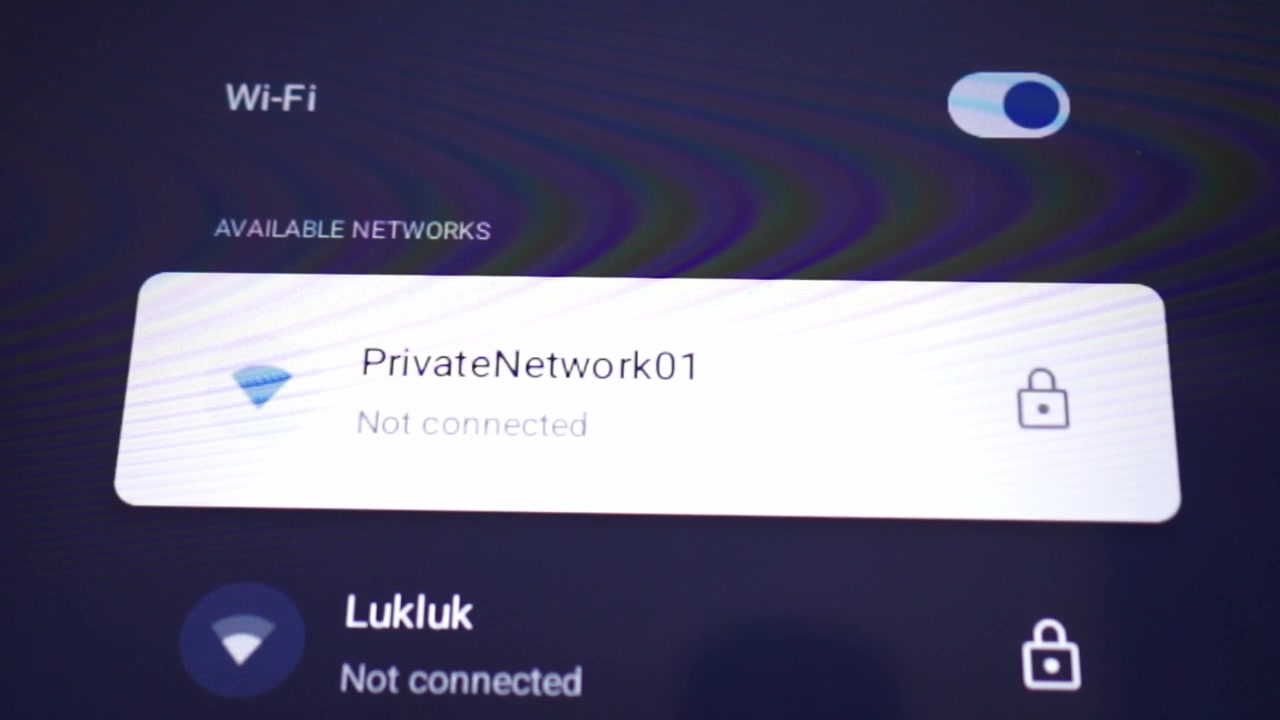 Selecting a WiFi network from a list of password-protected connections on a digital screen. Network setup, internet access and smart device interface.