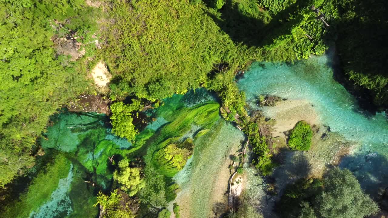 Ripresa drone a volo d'uccello dell'Occhio Blu in Albania - il drone sta scendendo, mostrando il suo bellissimo colore e l'acqua cristallina