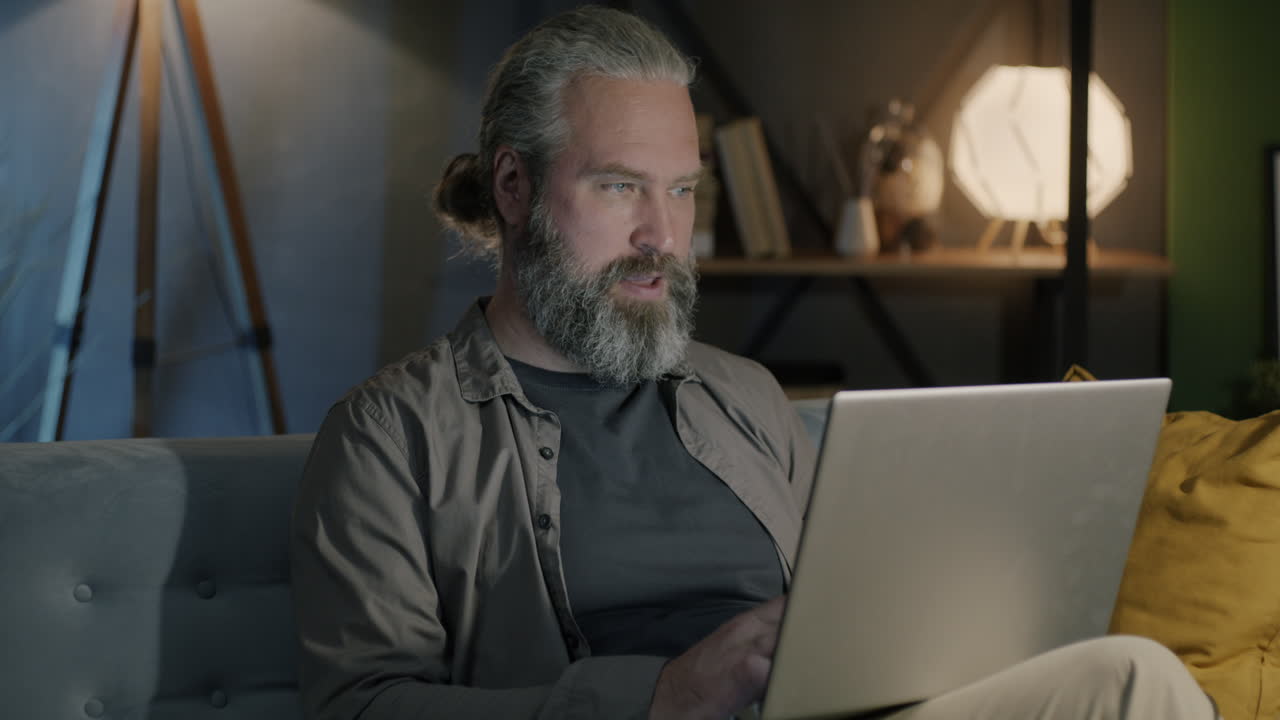 Mand, der arbejder på bærbar computer derhjemme