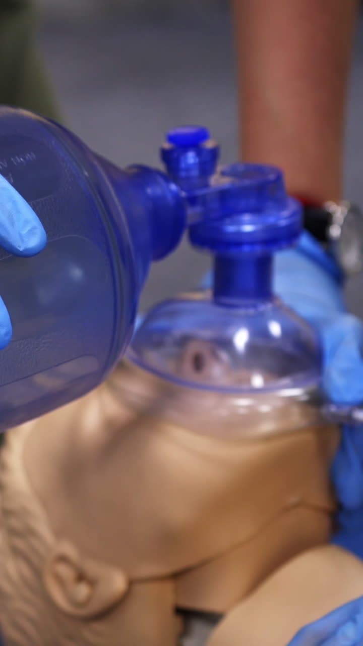Cardiopulmonary resuscitation. Training demonstration of a chest compression and breathing on a dummy. Close-up. Vertical video