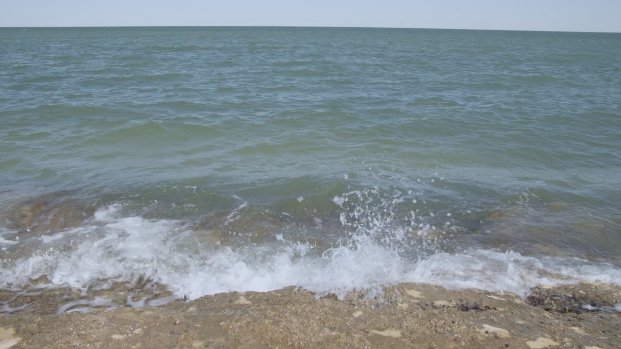 그리고 차분한 바다 파도가 깨 ⁇ 한 바위에 부 ⁇ 히고